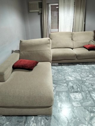 Sofá modular beige con cojines rojos