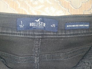 Top grigio e shorts neri strappati