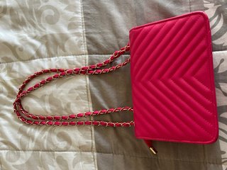 Bolso fucsia acolchado con cadena dorada