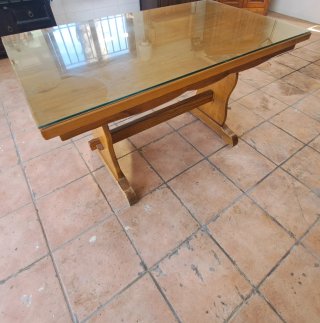 Mesa de comedor de madera y cristal grueso.