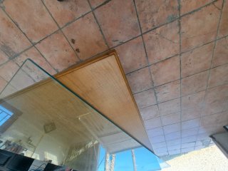Mesa de comedor de madera y cristal grueso.