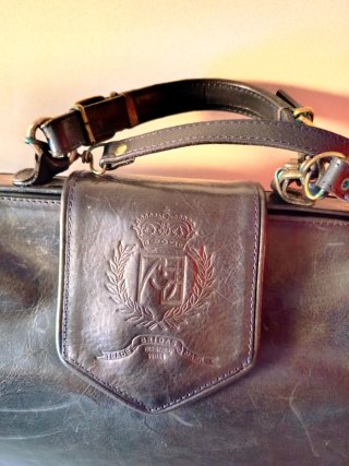 Bolso piel negro forma maletín.