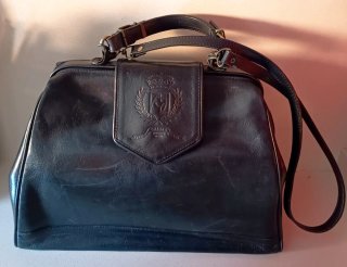 Bolso piel negro forma maletín.