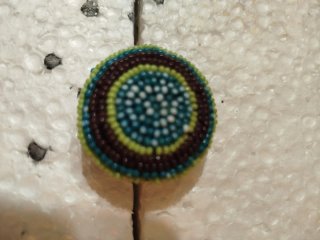 Anillo de cuentas multicolor. Es elástico.