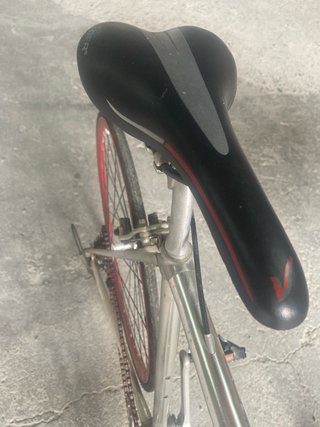 Bicicleta urbana plateada con ruedas rojas