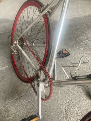 Bicicleta urbana plateada con ruedas rojas