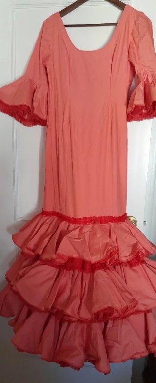 Traje de flamenca salmón con varios complementos.