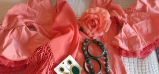 Traje de flamenca salmón con varios complementos.