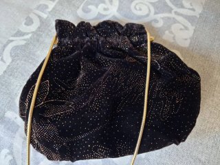 Bolso de mano negro con detalles dorados