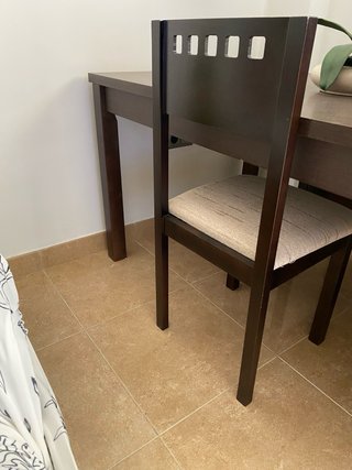 Mesa de comedor y sillas oscuras,