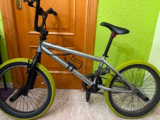 Bicicleta BMX plateada con ruedas amarillas