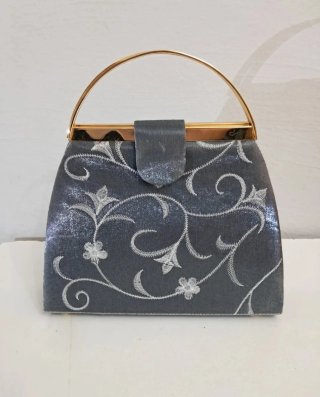 Bolso de mano gris con cadena dorada