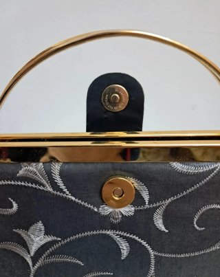 Bolso de mano gris con cadena dorada
