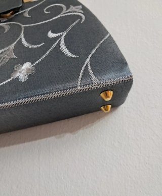 Bolso de mano gris con cadena dorada
