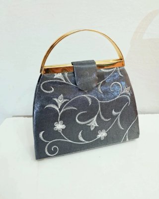 Bolso de mano gris con cadena dorada
