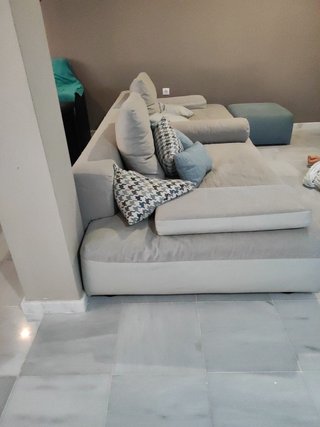 Elegante sofá modular gris y turquesa con puff