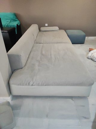 Elegante sofá modular gris y turquesa con puff