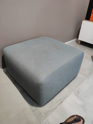 Elegante sofá modular gris y turquesa con puff