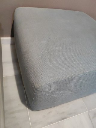 Elegante sofá modular gris y turquesa con puff