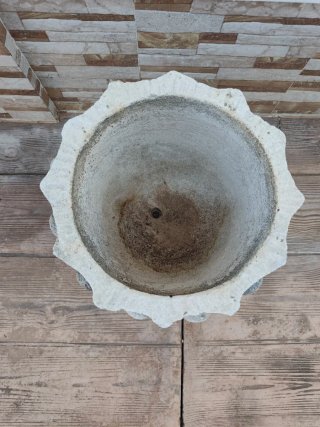 Macetero antiguo de piedra con capitel