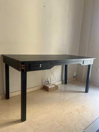 Escritorio negro con bandeja para teclado.