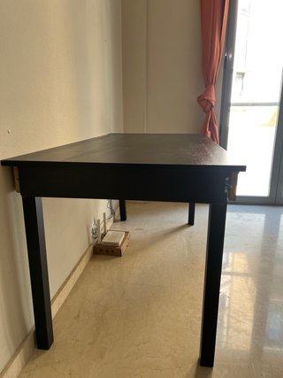 Escritorio negro con bandeja para teclado.