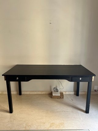 Escritorio negro con bandeja para teclado.
