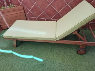 Tumbona de madera con cojín verde