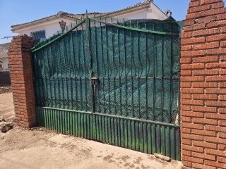 Puerta metálica verde con reja
