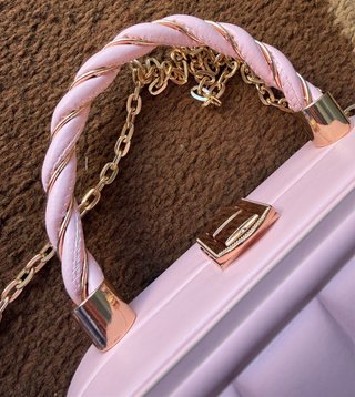 Bolso de mano rosa con cadena dorada
