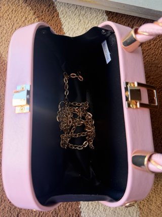 Bolso de mano rosa con cadena dorada
