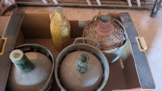 Antigüedades: Botella forrada, garrafas y maleta.