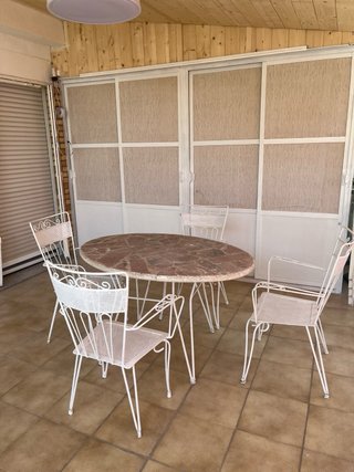 Conjunto mesa de piedra y sillas de forja exterior