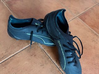 Botas de fútbol Puma Ultra negras y doradas
