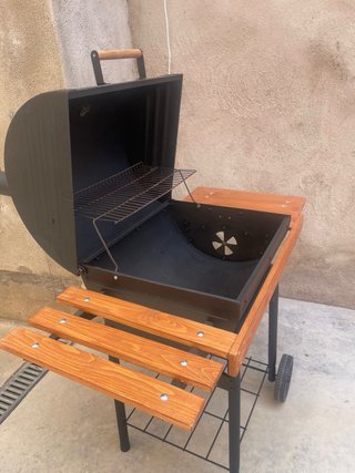 Barbacoa negra con mesas laterales de madera