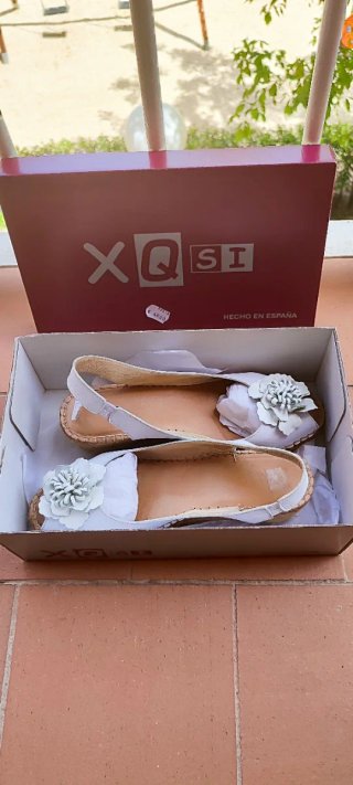 Sandalias piel blancas con flor de piel.