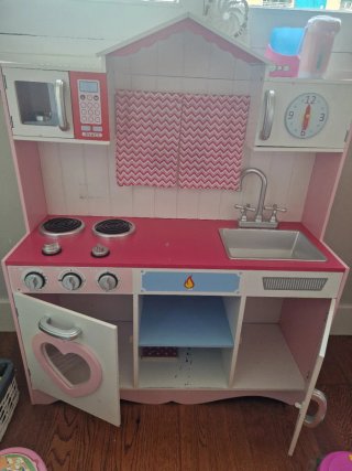Cocinita de madera rosa con accesorios