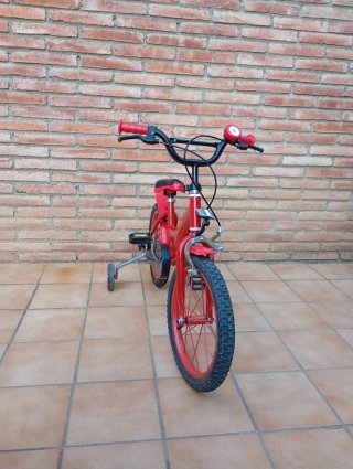 Bicicleta infantil vermella amb rodetes i timbre