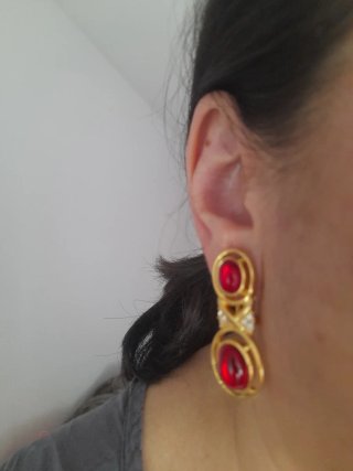 Pendientes dorados con piedra roja de clip.
