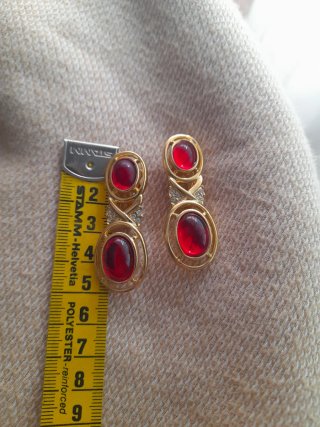 Pendientes dorados con piedra roja de clip.