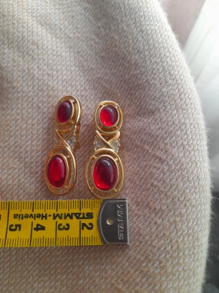 Pendientes dorados con piedra roja de clip.