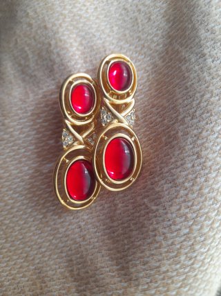 Pendientes dorados con piedra roja de clip.