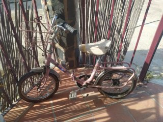 Bicicleta antigua rosa con cesta