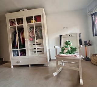 Armario infantil blanco con puertas decorativas.