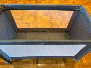 Cuna de viaje gris con funda y colchón
