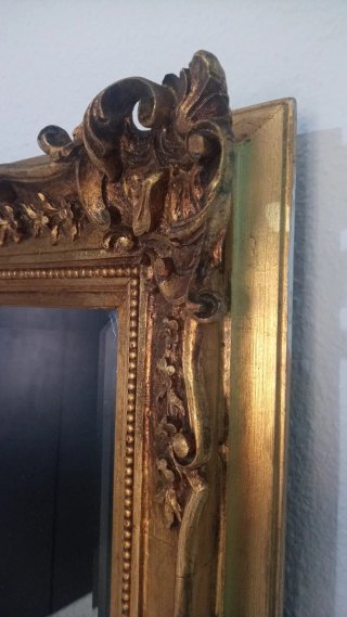 Espejo biselado dorado con marco tallado