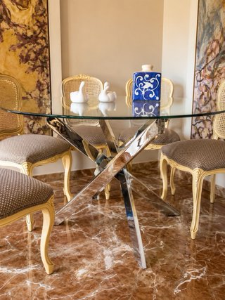 Mesa de comedor de cristal con pie de acero.