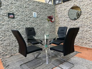 Mesa de cristal con 4 sillas negras