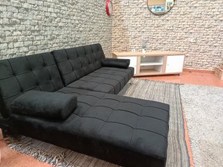 Sofá negro y mesa de TV madera