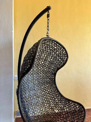 Comodo seggiolone a uovo in rattan nero con supporto